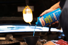 BlueDevil quart beside a tape measure showing bottle size
