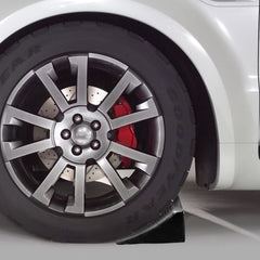 Fasmov chock placed against car wheel demonstrating secure parking stability