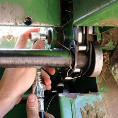 LockNLube beside grease gun for scale, compact low-profile benefit