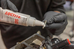 Loctite 565 nozzle close-up applying sealant, precise application reduces waste