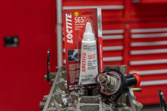 Loctite 565 sealing threaded metal fitting in engine bay, durable leak protection