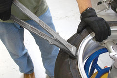 Motion Pro tool in use on motorcycle wheel demonstrating safe bead separation
