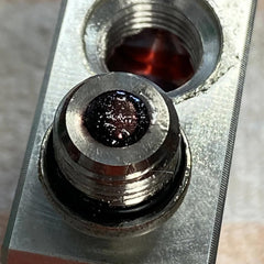 Pacific Performance Engineering close-up of neodymium magnet service plug capturing metal debris for easier maintenance