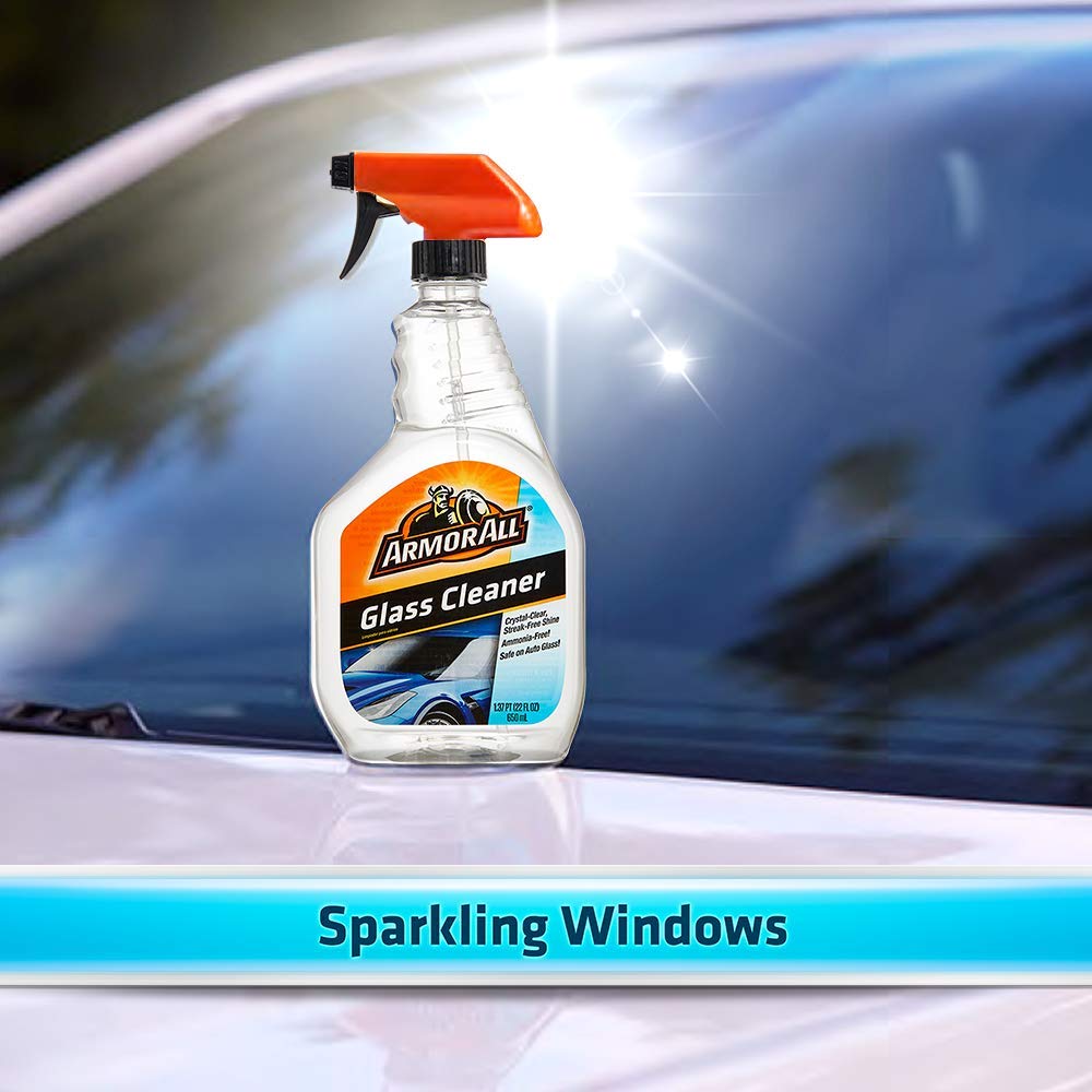 armor all spraying on windshield removing road grime for improved driving visibility