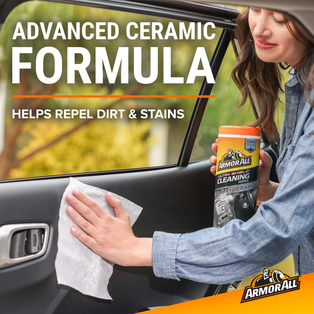 Hand using Armor All wipe on dashboard demonstrating quick clean and protect