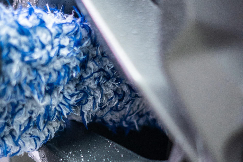 Autofiber brush in use between wheel spokes demonstrating targeted grime removal