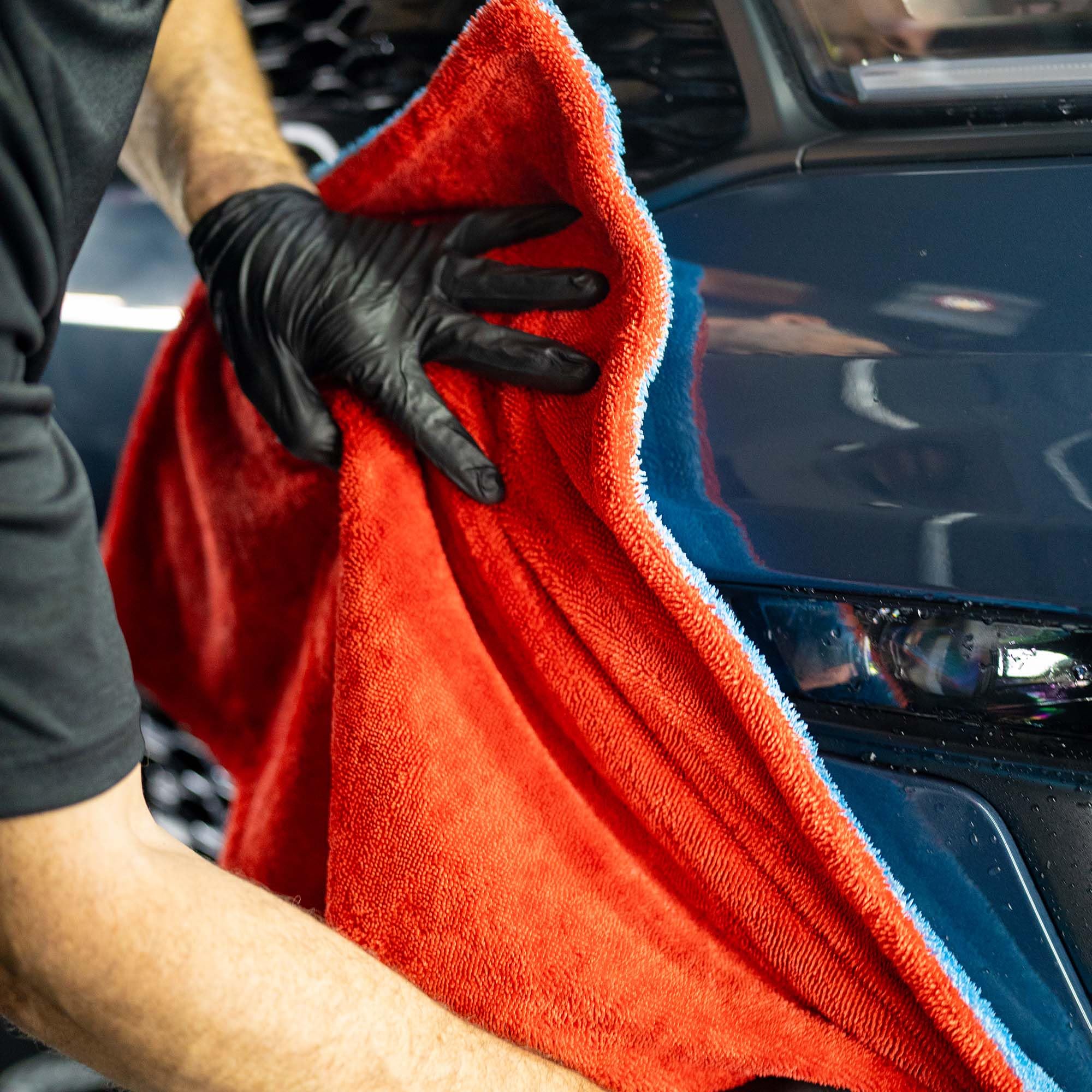 Autofiber towel beside hands to show 20x30 size for manageable coverage and control