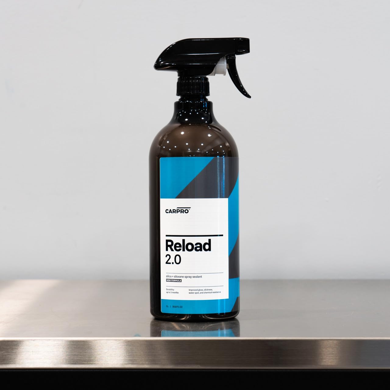 CARPRO Reload close-up on glossy paint reflecting light to show enhanced shine benefit