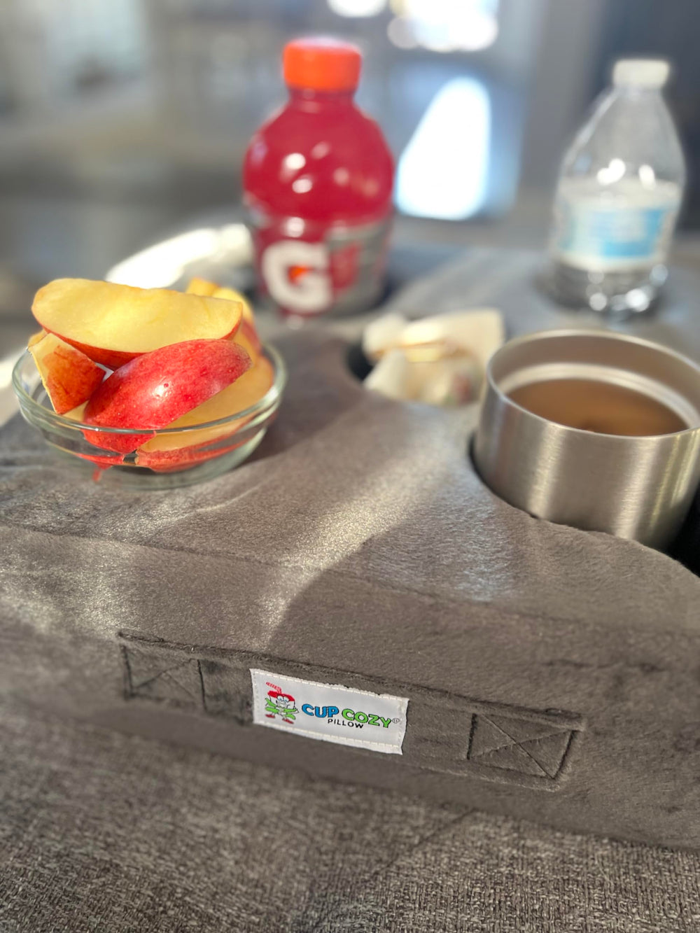 Cup Cozy Pillow on car seat providing stable cup and device placement while traveling