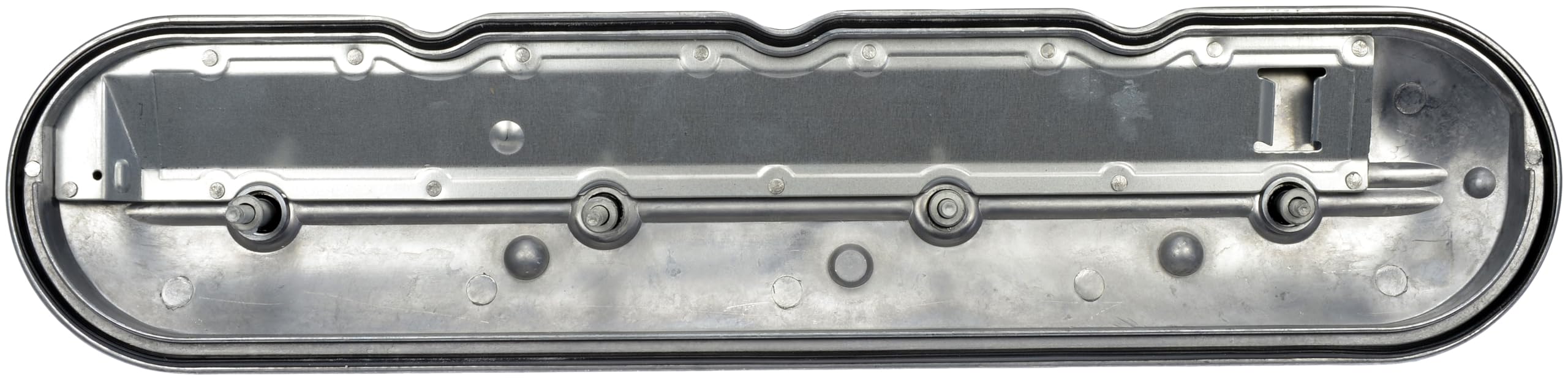Dorman valve cover beside ruler for size comparison and fit confirmation