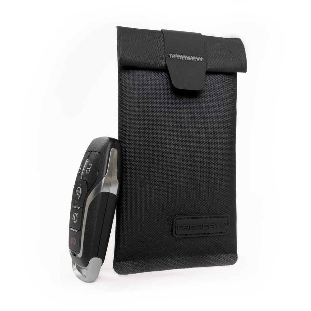 Faraday Defense with keys, credit card, and USB inside demonstrating multi-device shielding use
