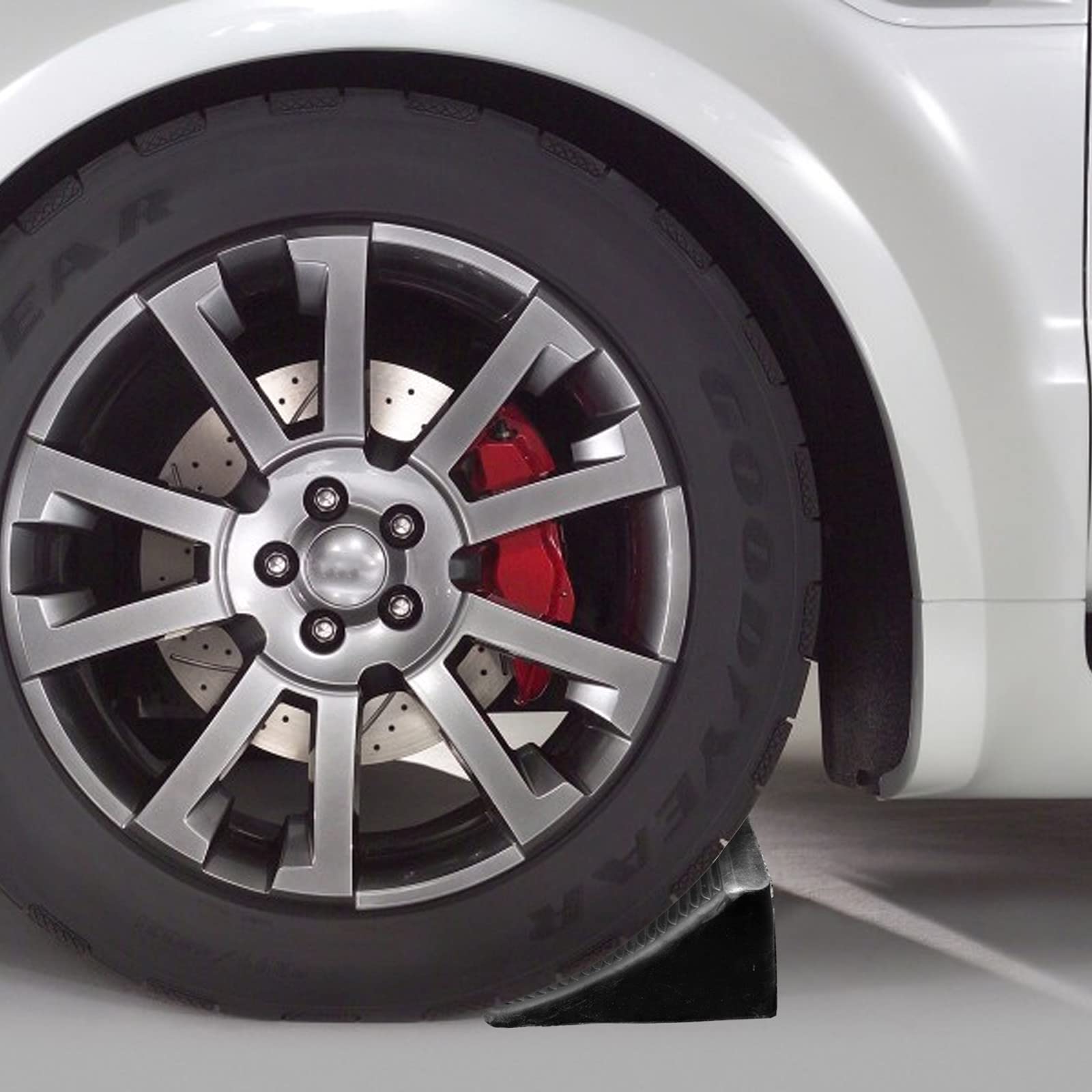 Fasmov chock placed against car wheel demonstrating secure parking stability