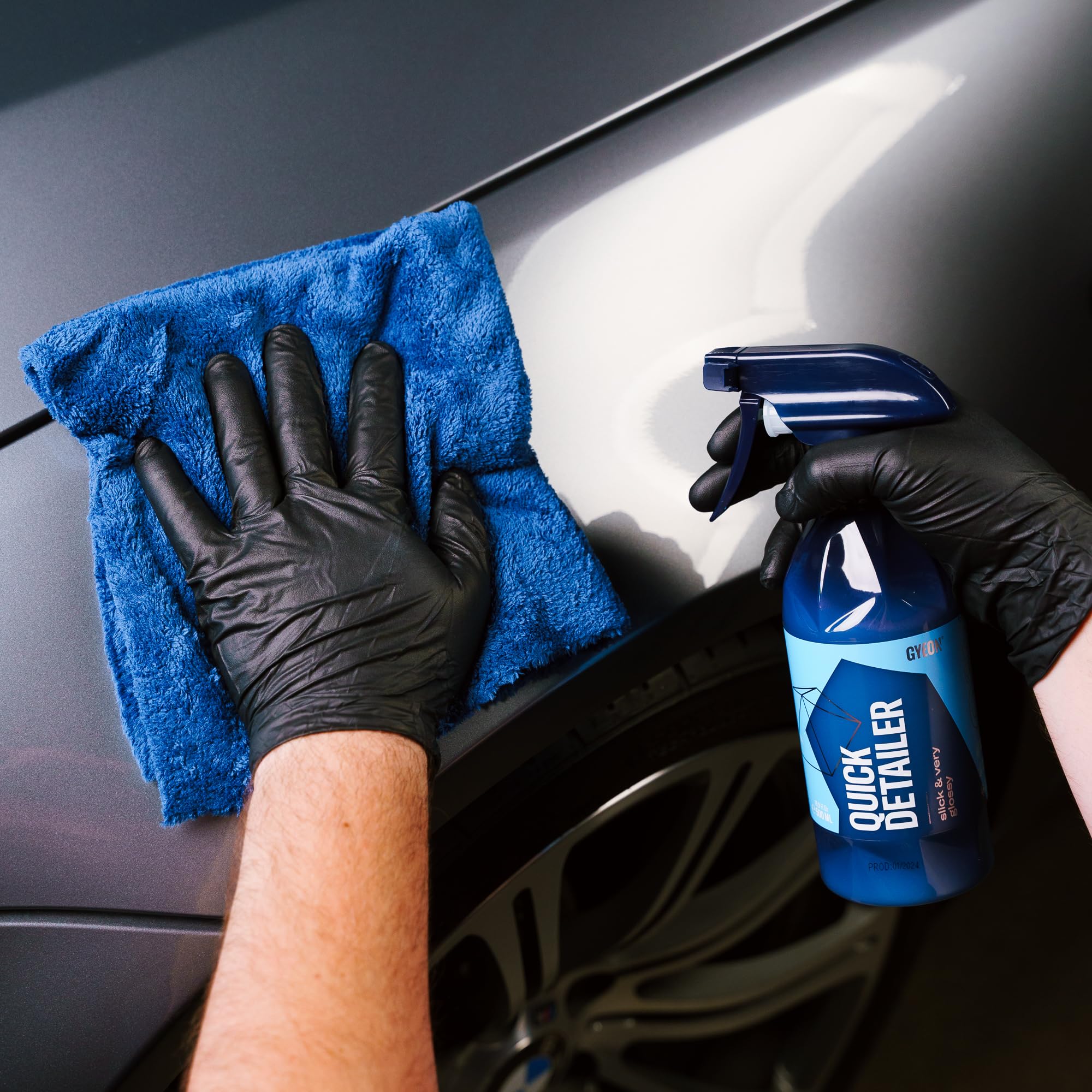Gyeon quick detailer 500ml bottle beside a hand for size and scale