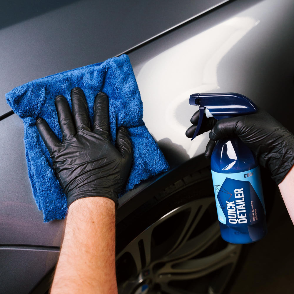 Gyeon quick detailer 500ml bottle beside a hand for size and scale