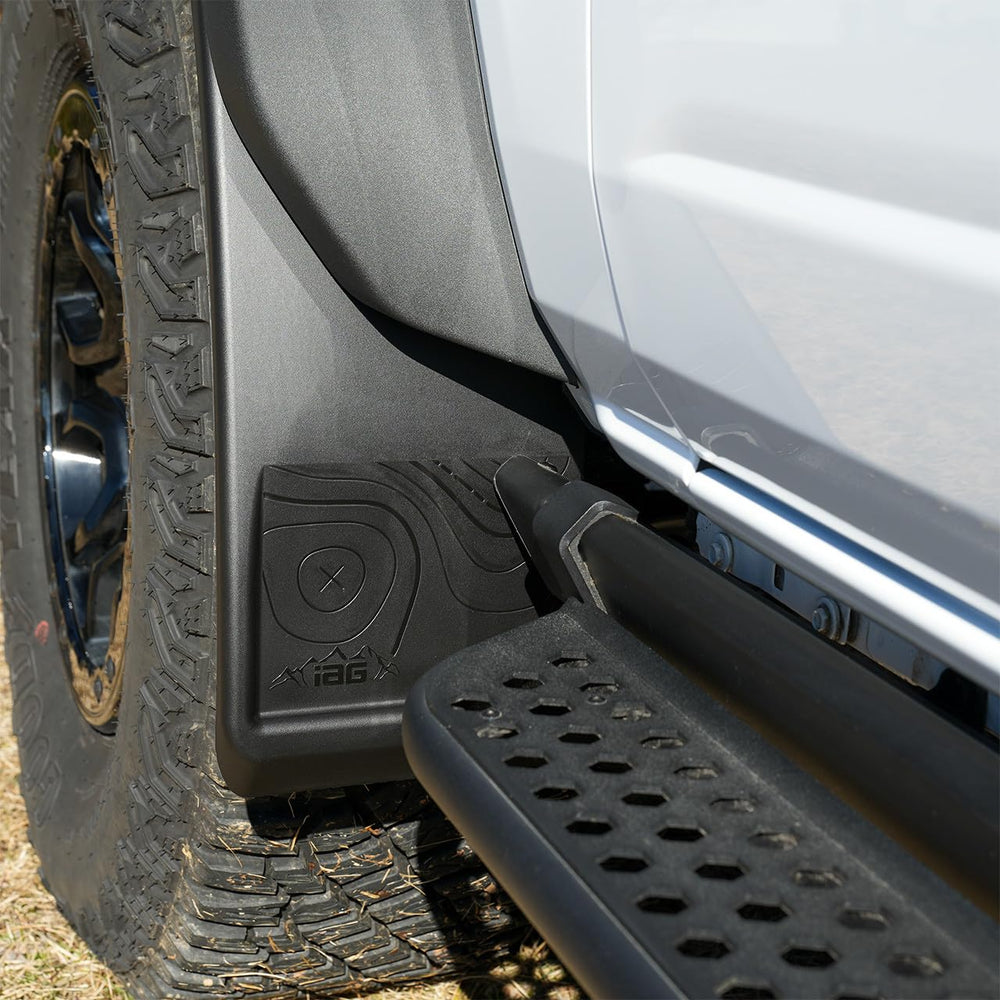 IAG Performance mud flap beside tire showing adjustable width and scale