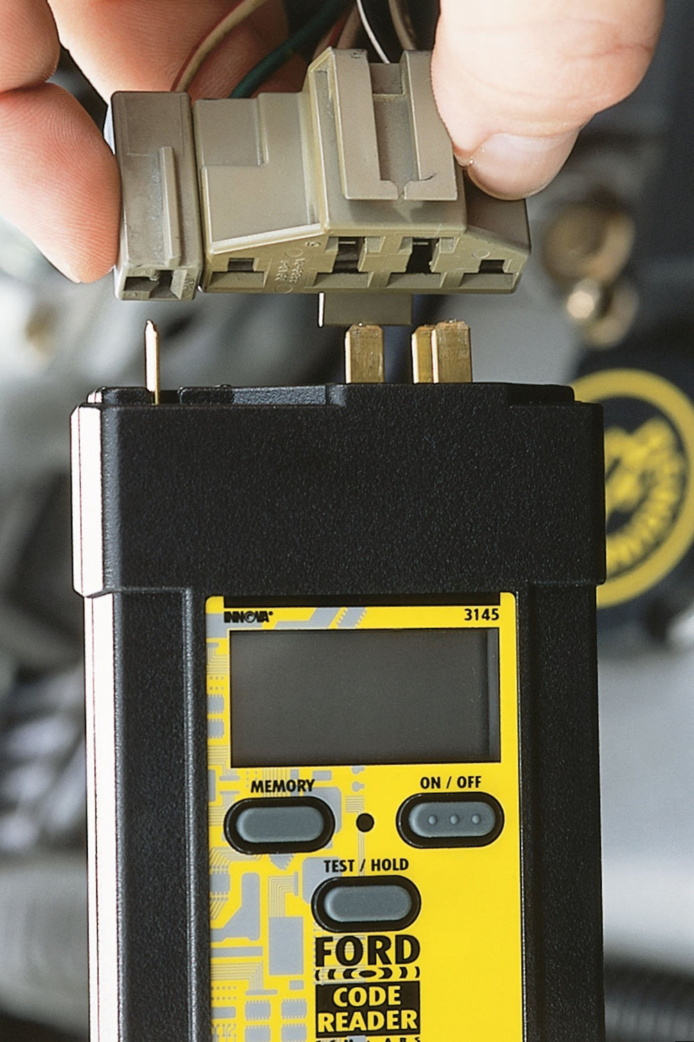 Innova 3145 connector close-up plugging into Ford diagnostic port for instant access