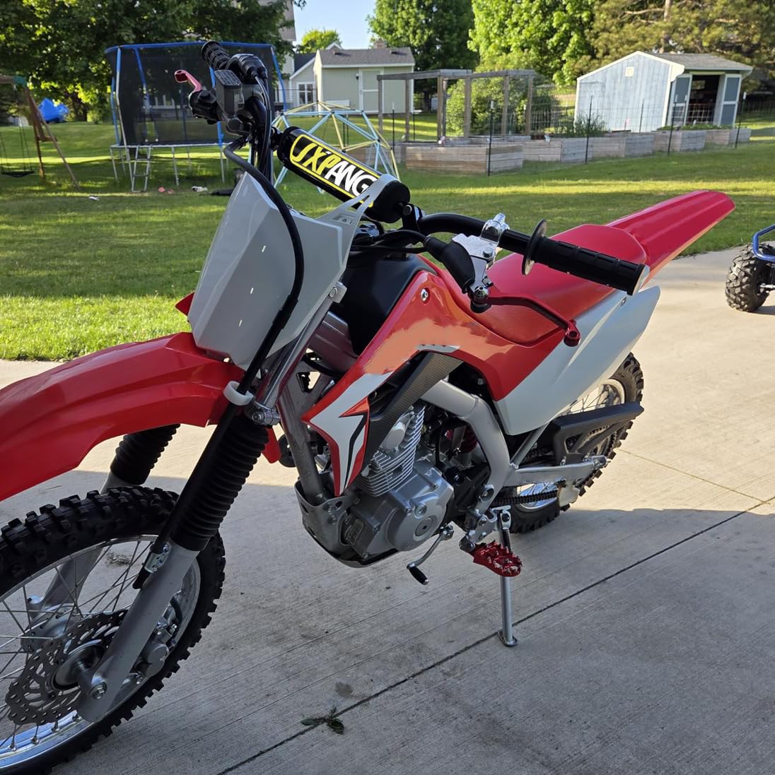 JXPANG installed on a dirt bike in trail setting showing ergonomic riding benefit