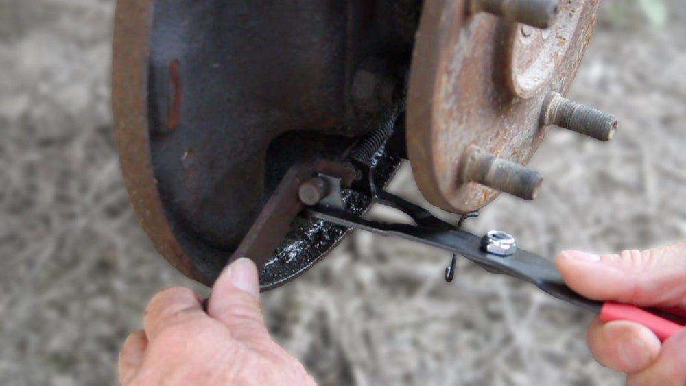 Lisle 44210 compressing an emergency brake cable spring allowing one-handed service