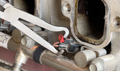 Lisle pliers in use disengaging a sensor connector in a tight engine bay for safe removal