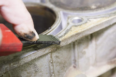 Lisle scraper in use on intake manifold demonstrating efficient gasket and carbon removal