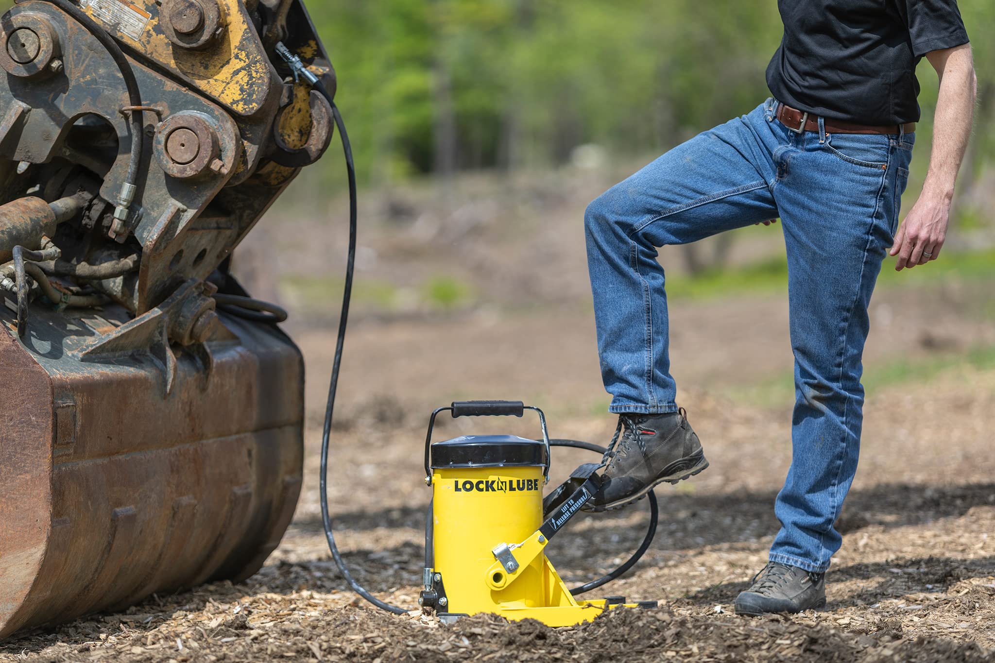 LockNLube G.Gun in a workshop lubricating heavy machinery for faster maintenance