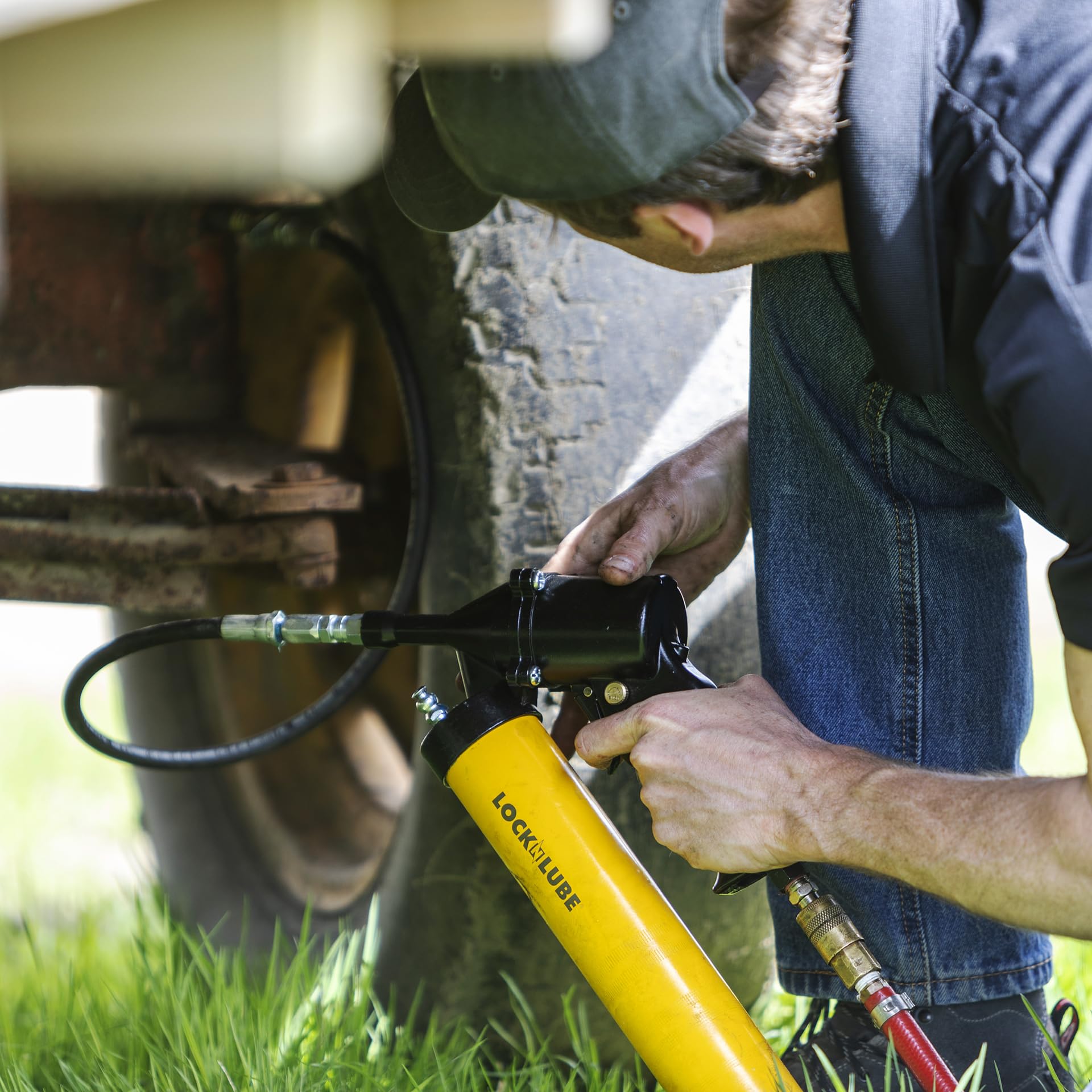 LockNLube grease gun in use on a truck U-joint demonstrating faster multi-point service benefit