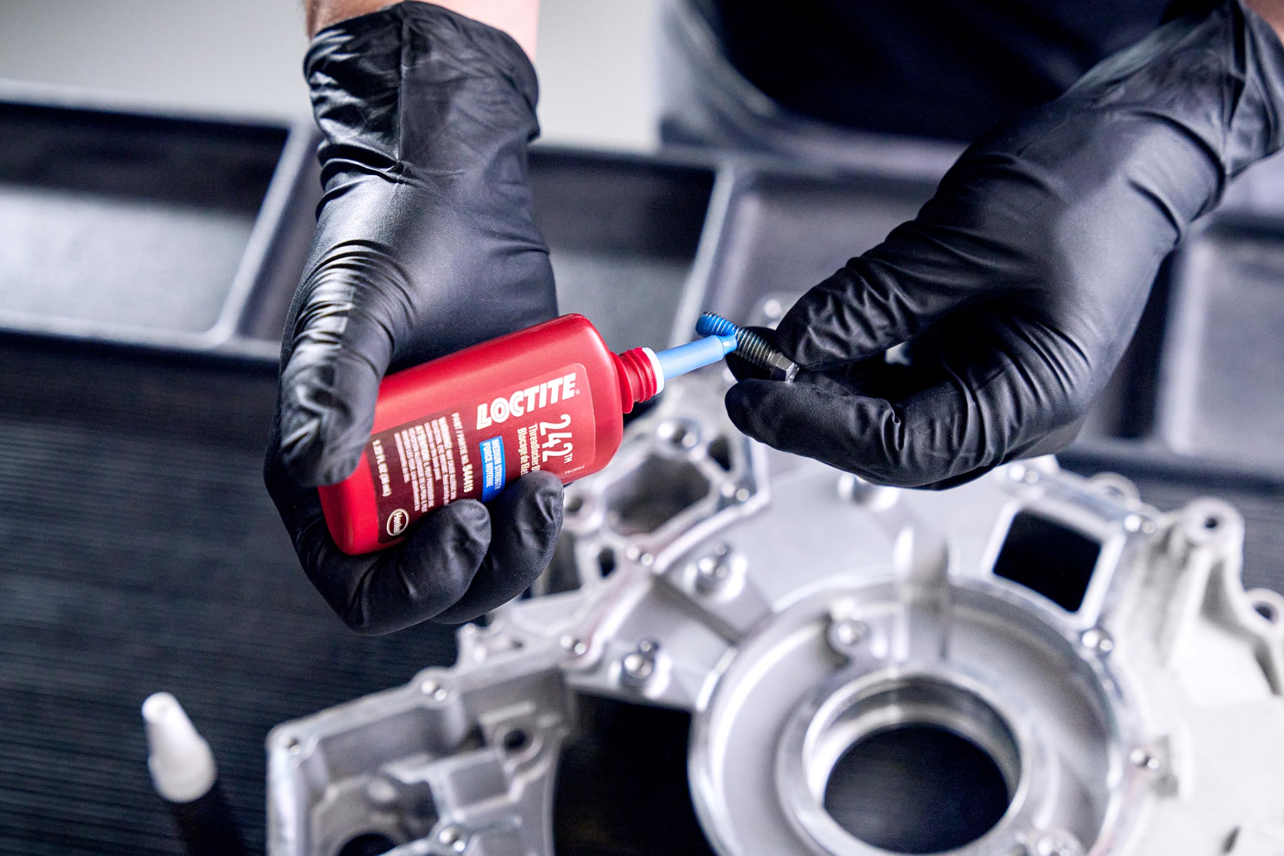 Loctite 242 on a garage workbench with tools showing readiness for vehicle maintenance