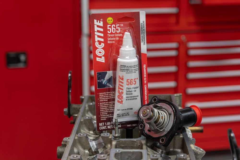 Loctite 565 sealing threaded metal fitting in engine bay, durable leak protection