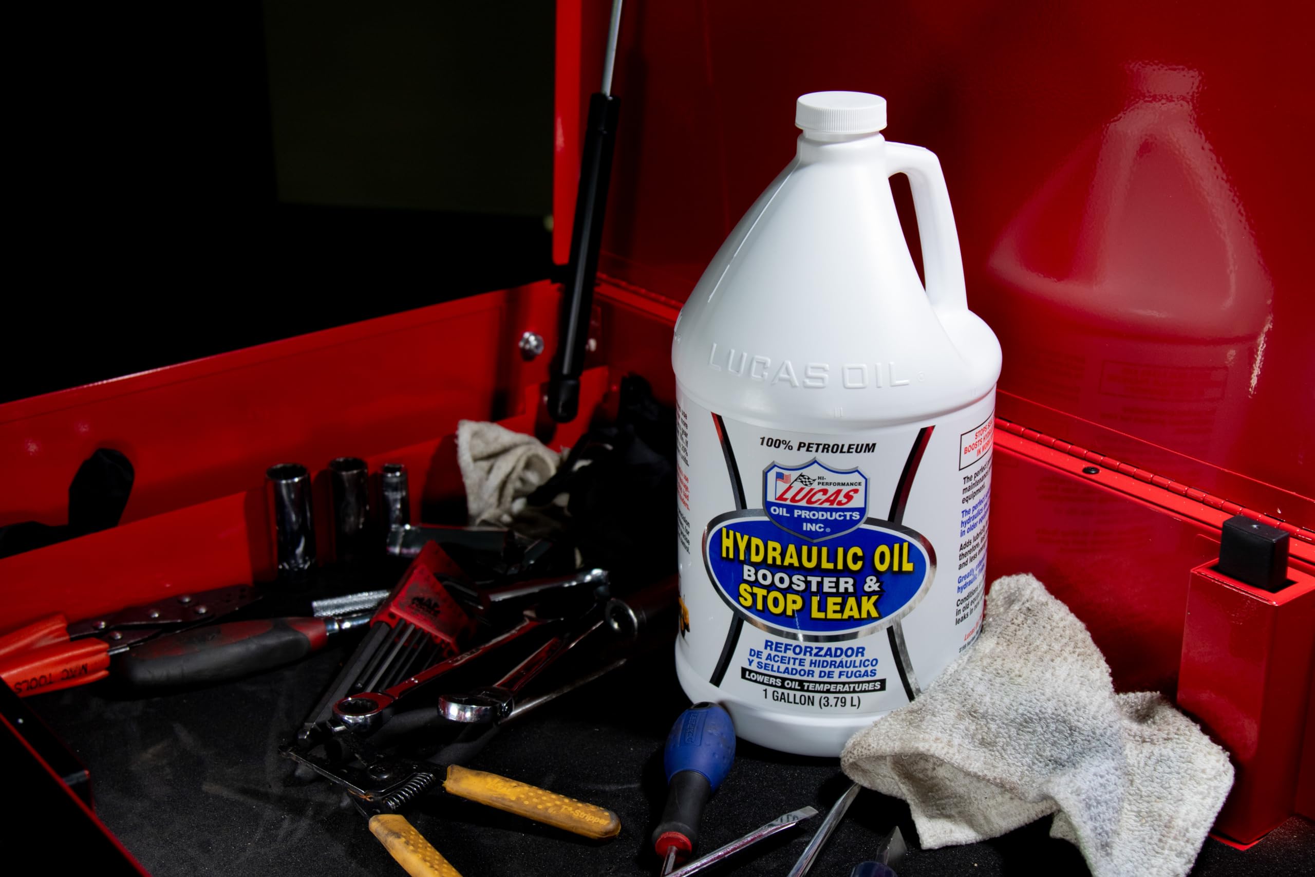 Lucas Oil bottle beside tools illustrating recommended dosing scale