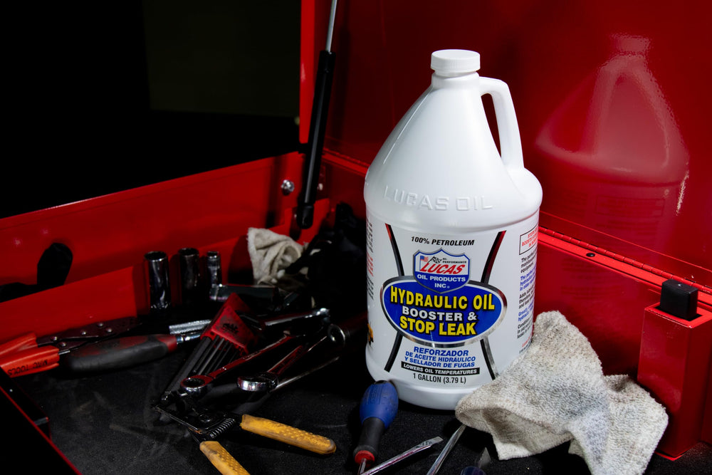 Lucas Oil bottle beside tools illustrating recommended dosing scale