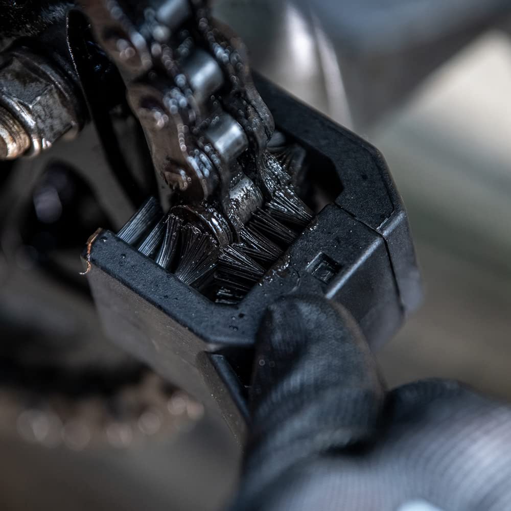 Muc-Off long brush close-up reaching sprocket gaps for precise debris removal