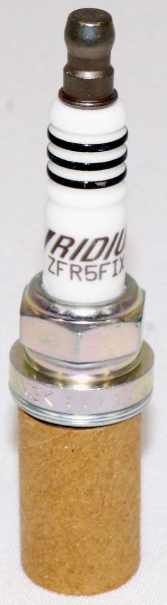 NGK spark plug held in hand to show real-world size and scale