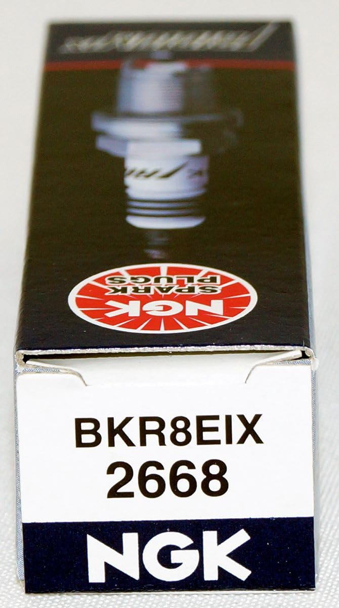 NGK BKR8EIX on workbench in garage lifestyle shot suggesting professional-grade performance