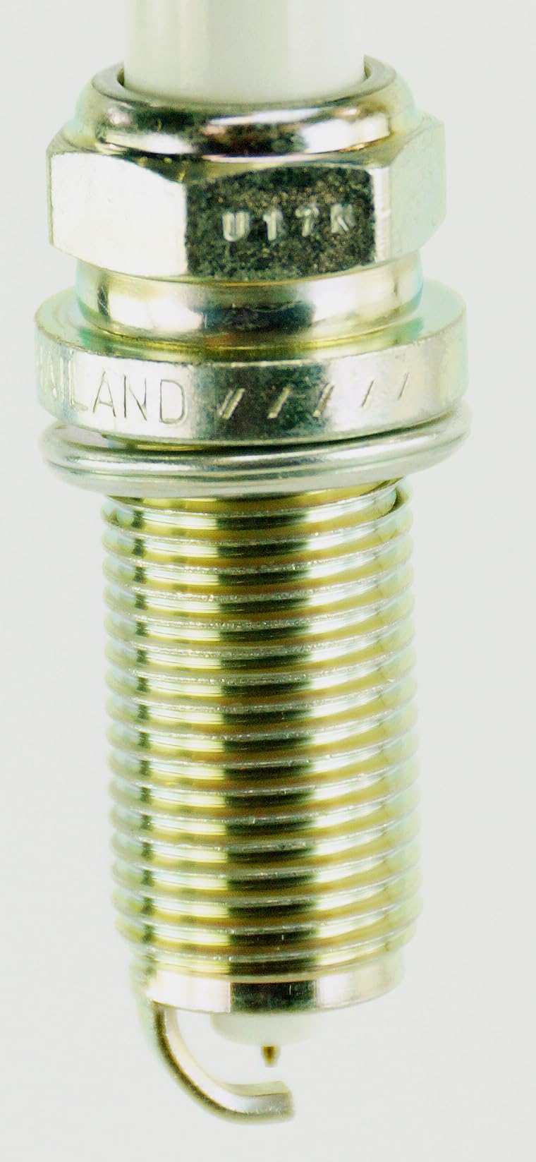 NGK G-Power LFR6CGP next to a coin for scale showing compact size and correct reach