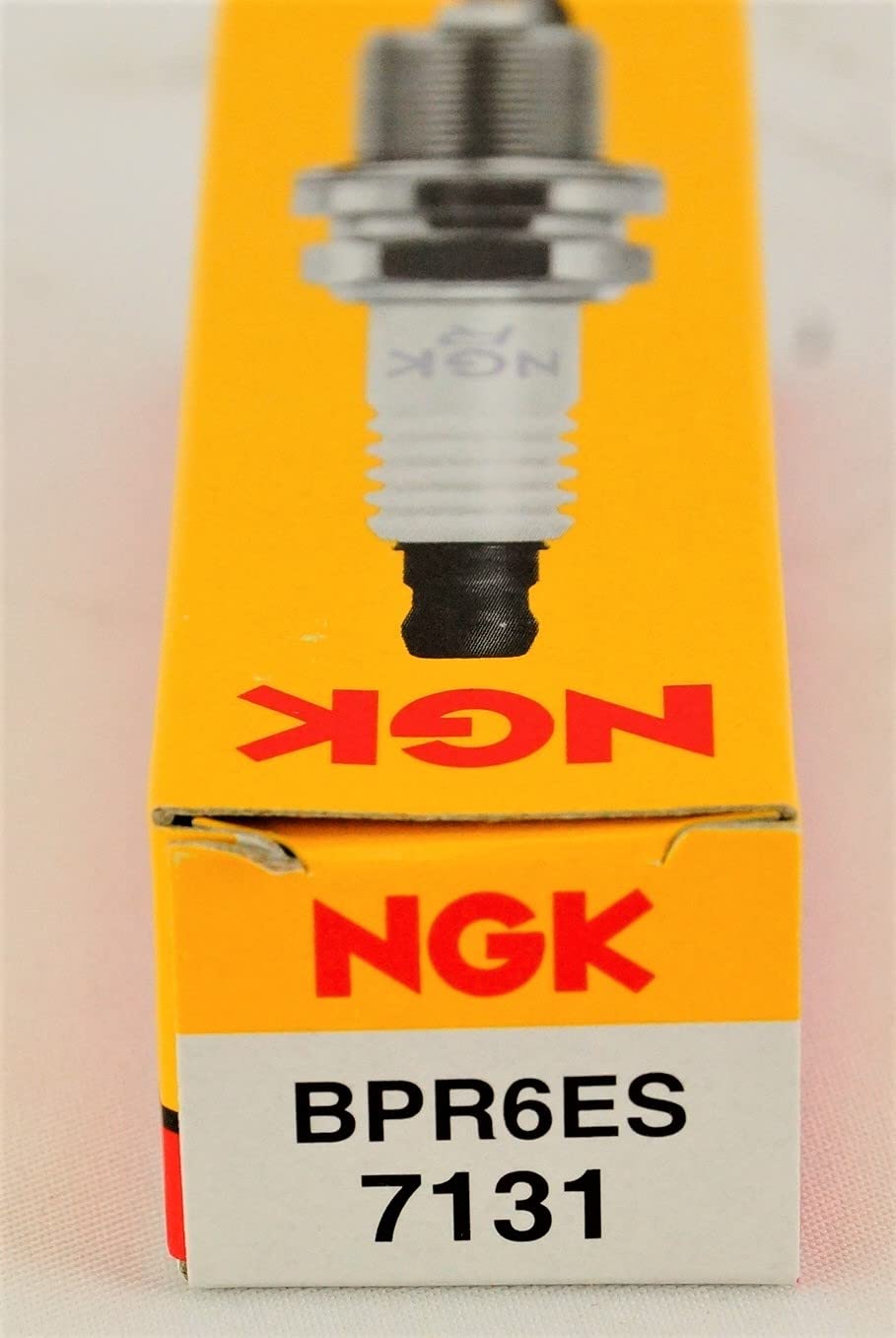 NGK spark plugs in garage setting ready for routine maintenance and replacement