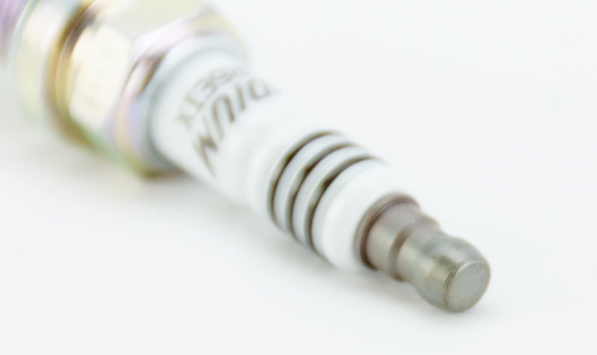 NGK four plugs held in hand to show scale and easy installation
