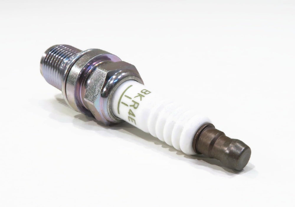 NGK spark plug with socket tool illustrating safe removal and installation technique