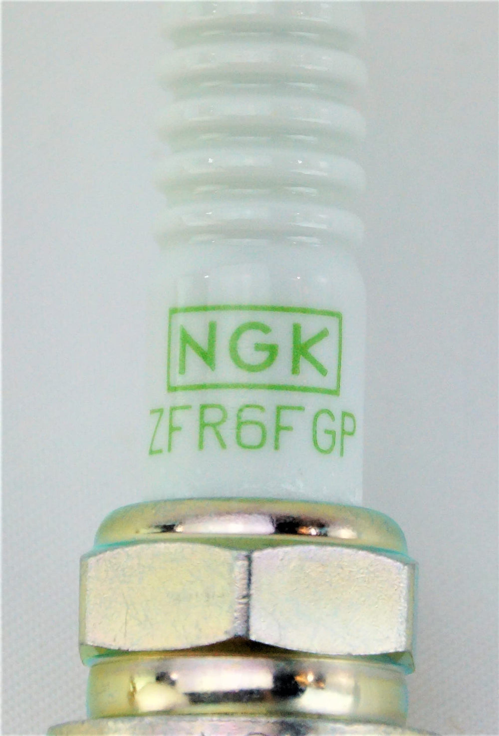 NGK spark plug next to a ruler showing size and reach for accurate compatibility check