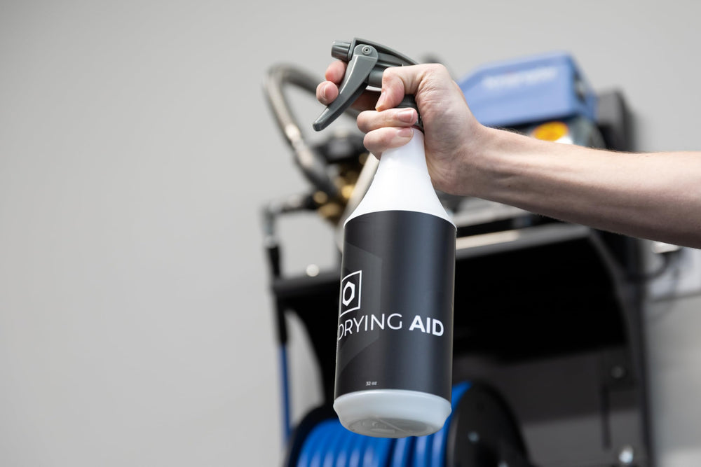 Detailing setup with bottle, towels and car, OBSESSED GARAGE simplifies finishing steps