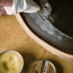 Otter Wax being rubbed into a leather boot for waterproof protection benefit