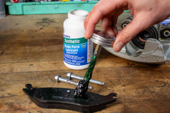 Permatex applied to brake pad back reducing noise and protecting metal contact areas