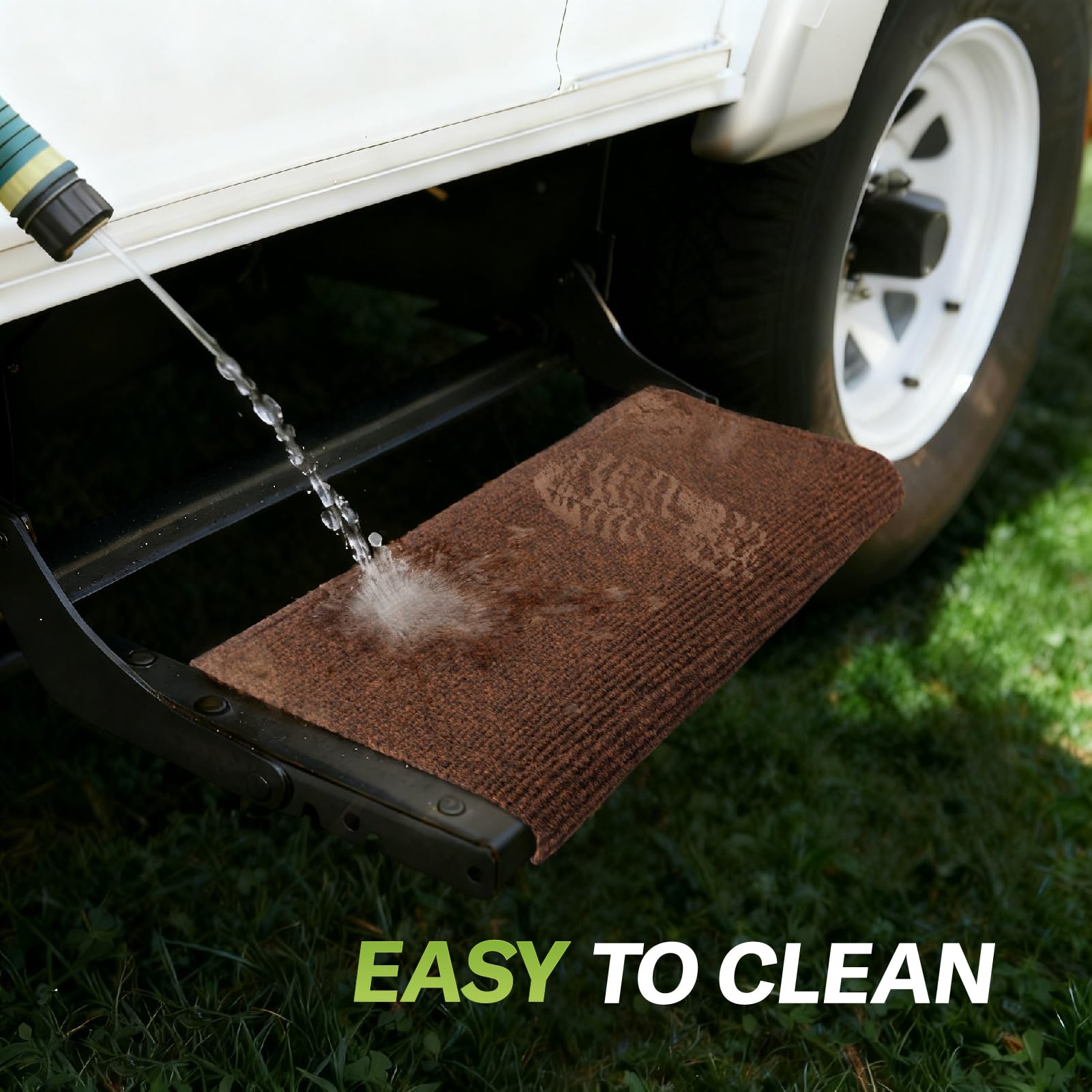 RVMATE step rug being hosed clean outdoors showing easy-care maintenance benefit