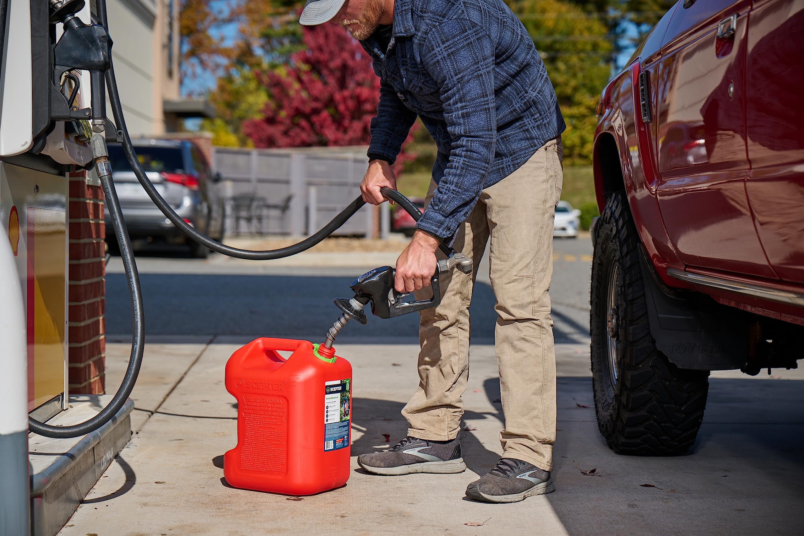 Scepter pouring into a lawnmower tank demonstrating clean, accurate fueling