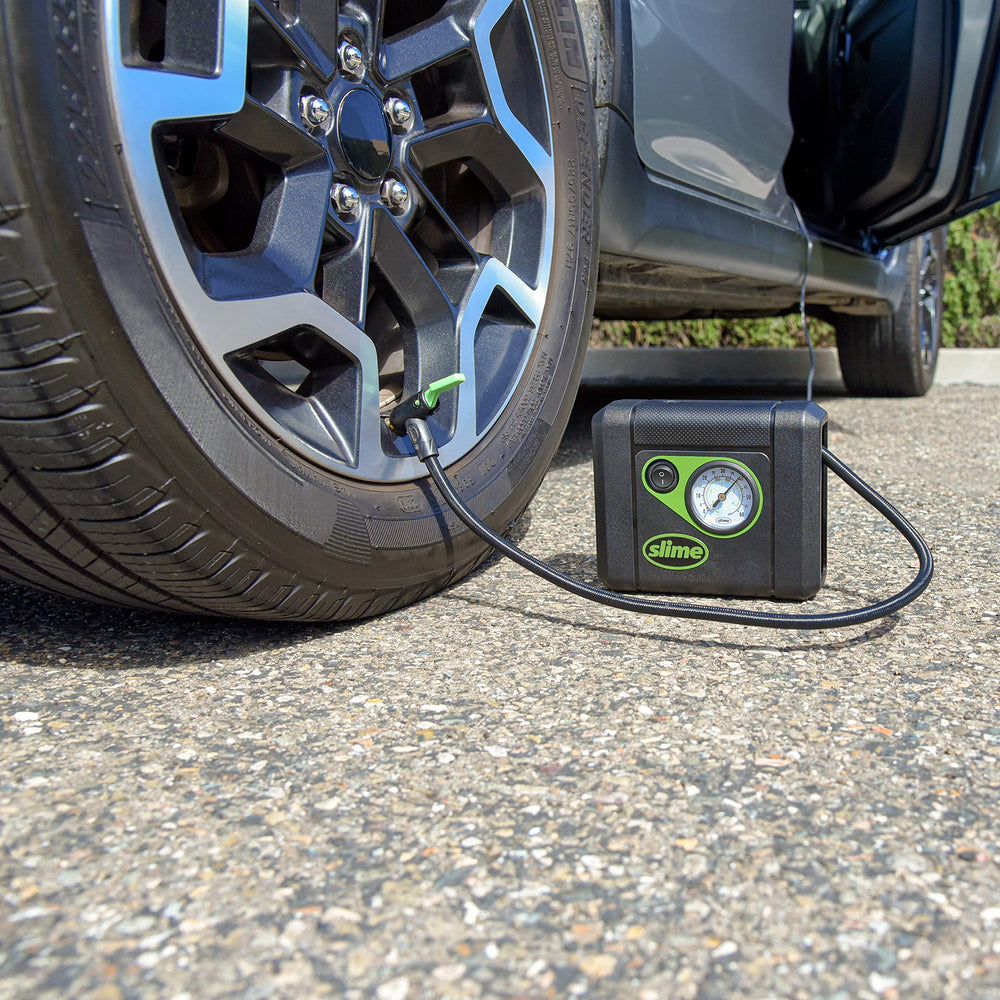 Slime inflator in use inflating a car tire for roadside emergency support