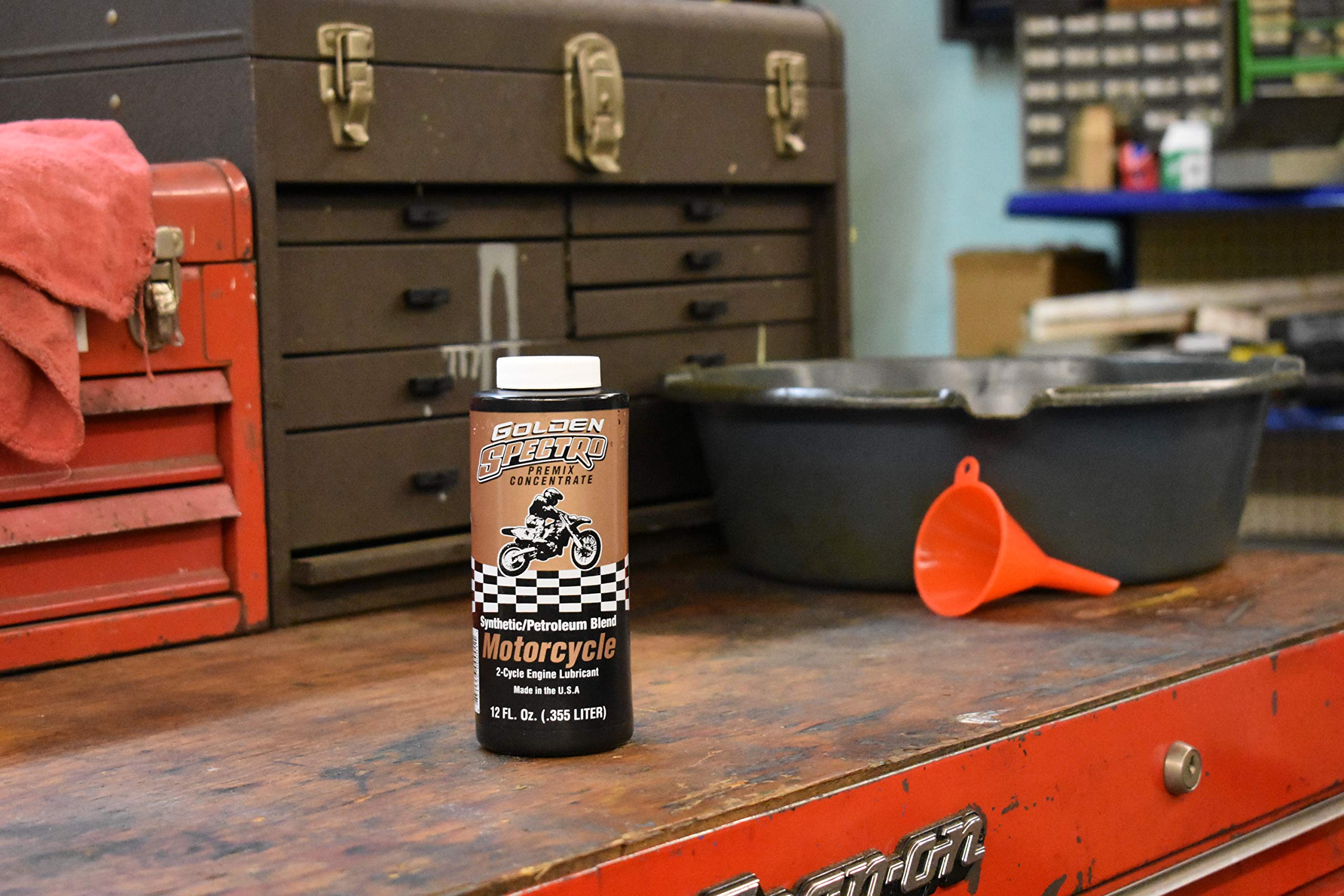 Spectro Oil 12 oz bottle held in hand showing scale and convenient storage size