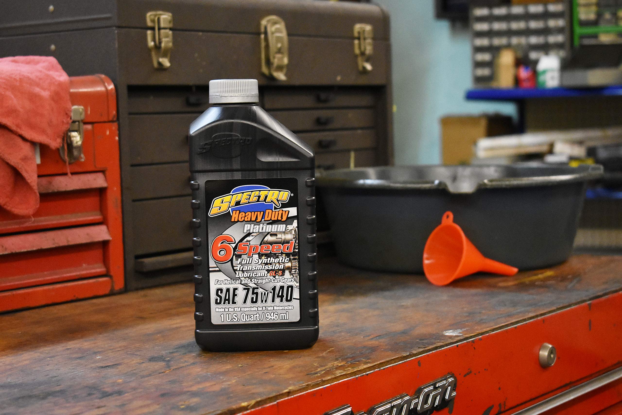 Spectro Oil on workbench with motorcycle in background showing protection benefit