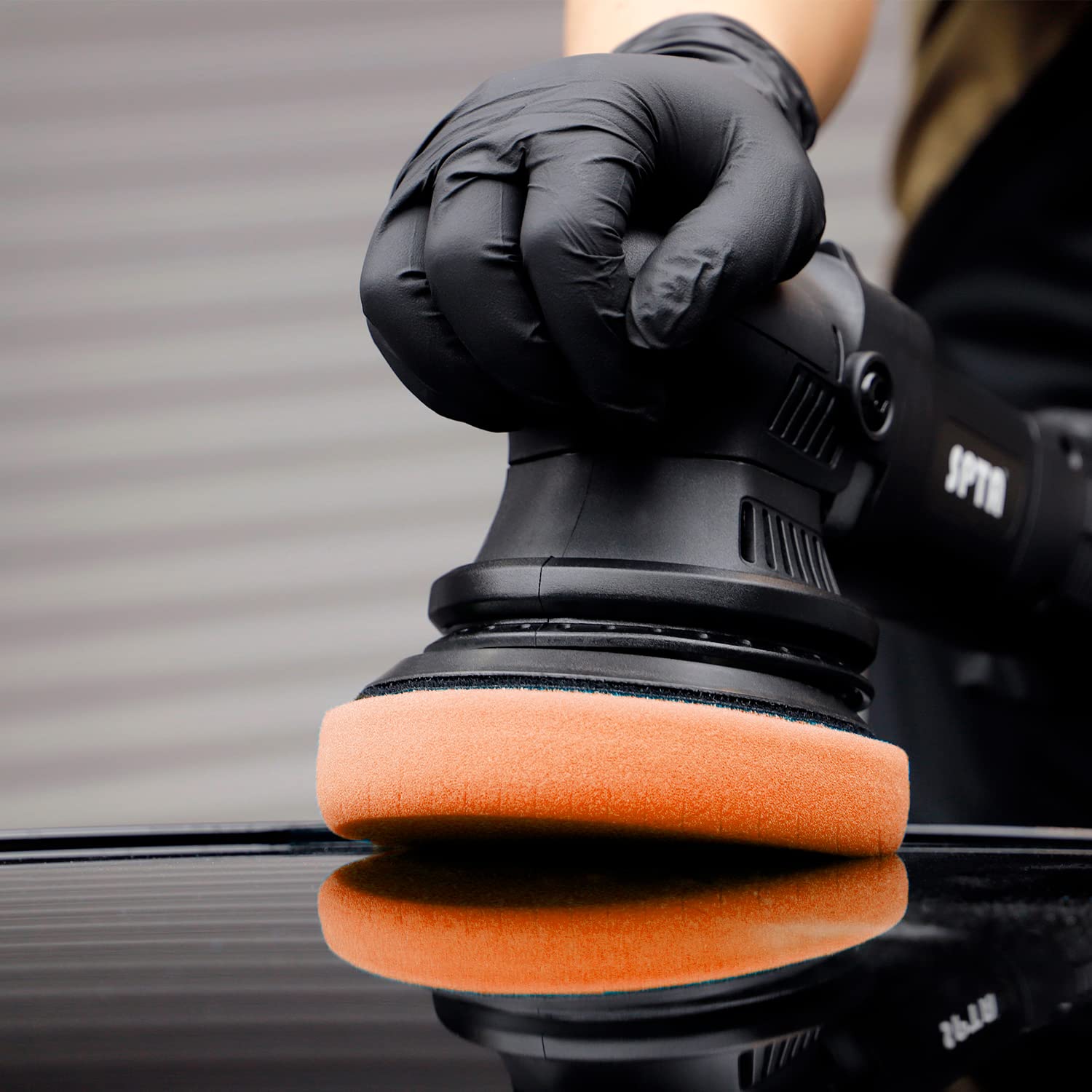 SPTA pads arranged with polisher and compounds showing professional detailing setup