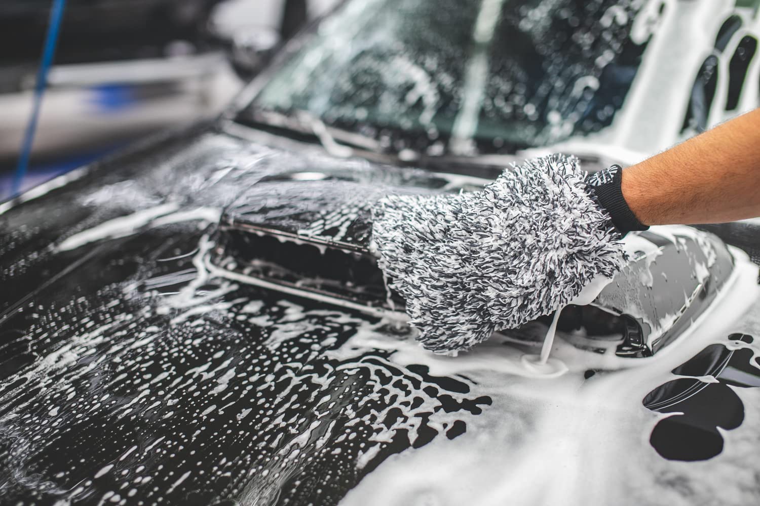 The Rag Company mitt held in hand demonstrating ergonomic grip and safe washing benefit