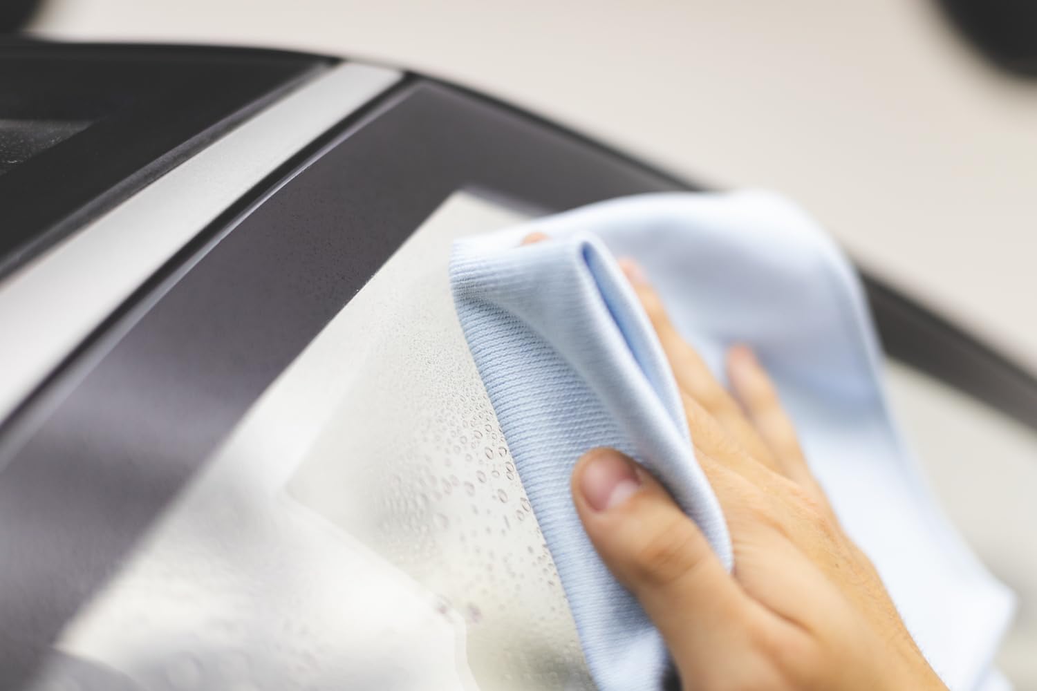 The Rag Company towel polishing a bathroom mirror, creating a streak-free reflection for homeowners