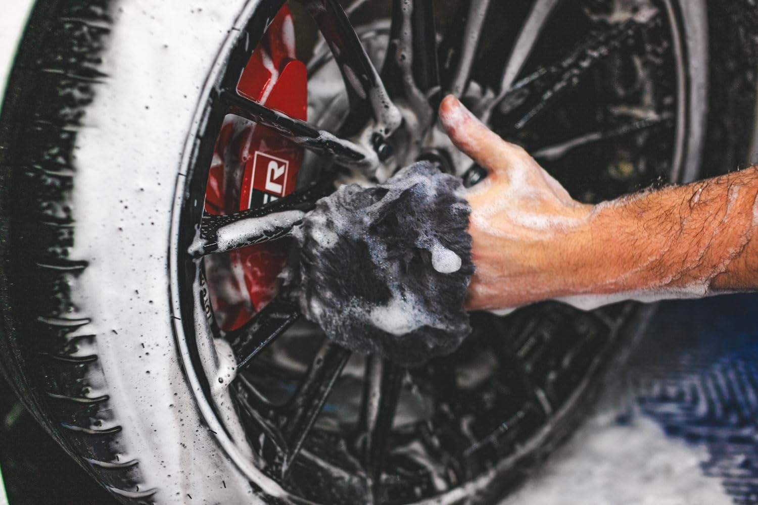 The Rag Company mitt next to a hand showing scale and ergonomic, comfortable fit